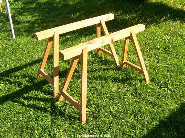 Böcke stehen einzeln auf einer Wiese.