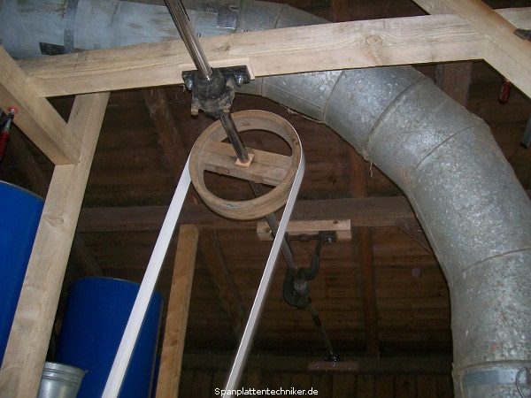 Ein Techniker bei der Reparatur bzw. Montage eines Flachriemenrades.