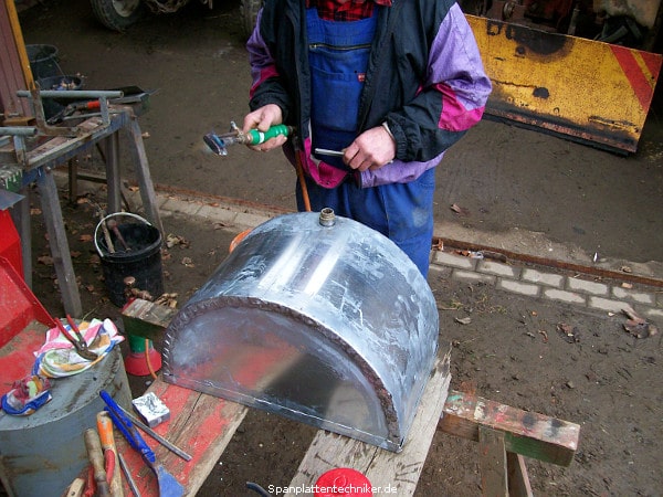 Ein Techniker baut lötet zwei Metallstücke zusammen.